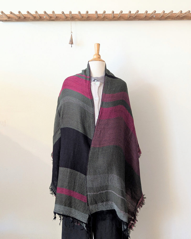 Mannequin wearing a striped shawl with gray, purple, and black colors on a white background.