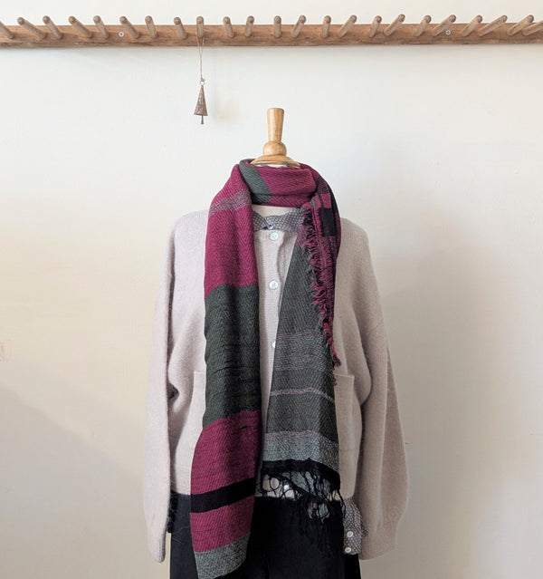 Mannequin wearing a stripe scarf with a neutral background