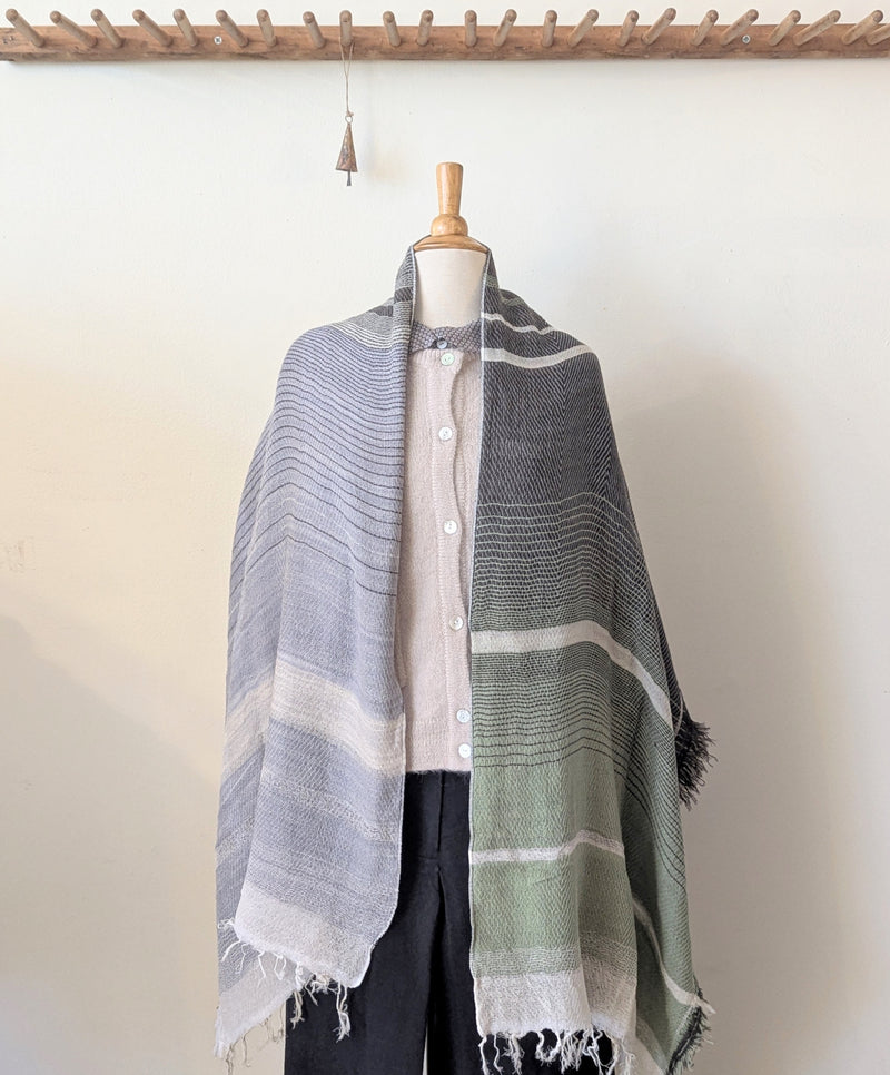 Mannequin wearing a striped scarf with a plain background