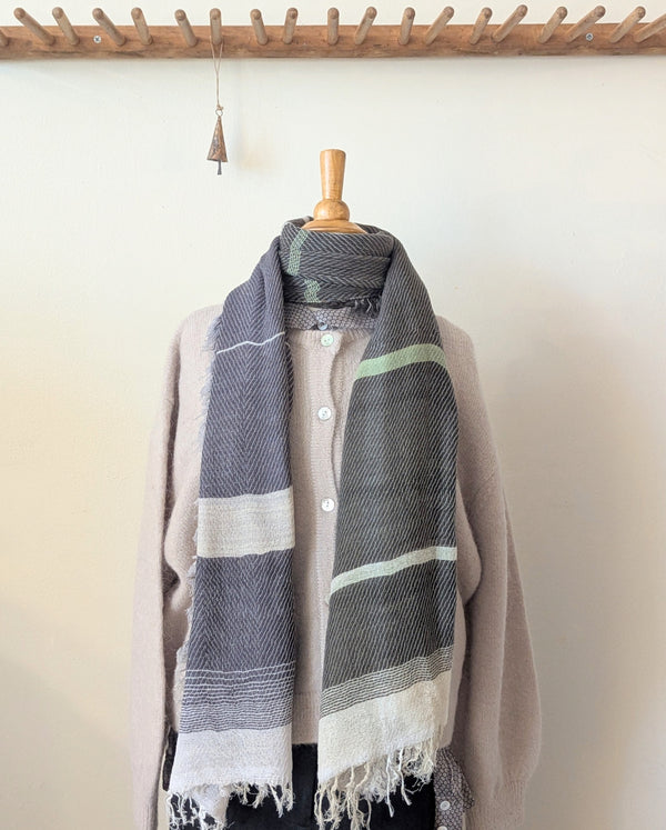 Scarf draped over a mannequin against a plain background