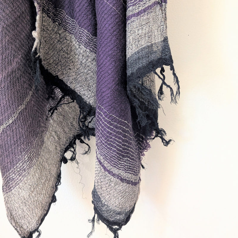 Textured scarf with purple and gray tones on a light background