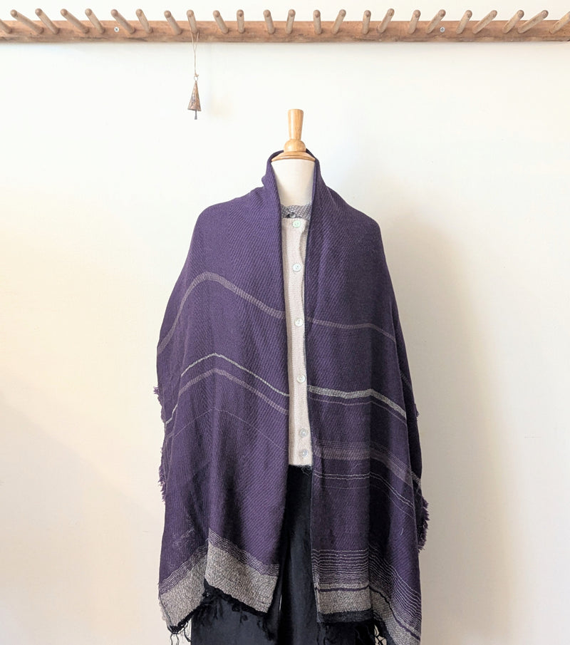 Mannequin wearing a purple and gray striped scarf against a white background