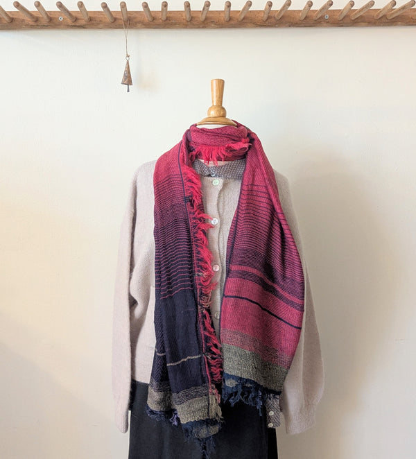 Mannequin wearing a scarf with a white shirt and dark pants against a plain background