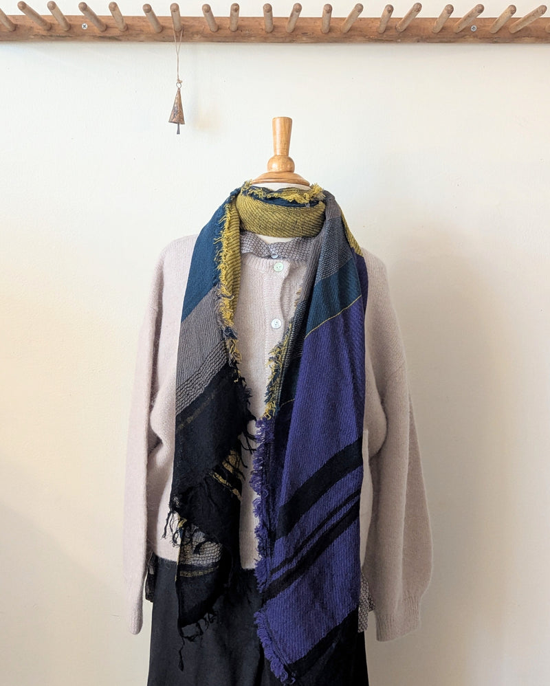 Colorful scarf draped over a mannequin against a white wall