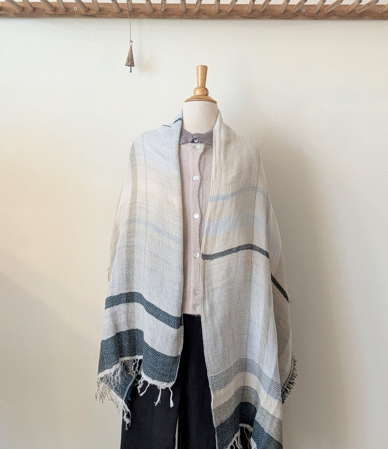 Mannequin wearing a striped shawl with a plain background