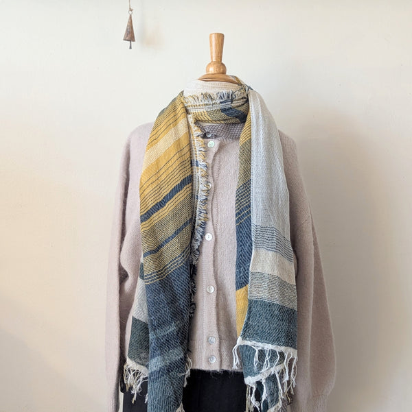 Plaid scarf draped over a mannequin against a plain background