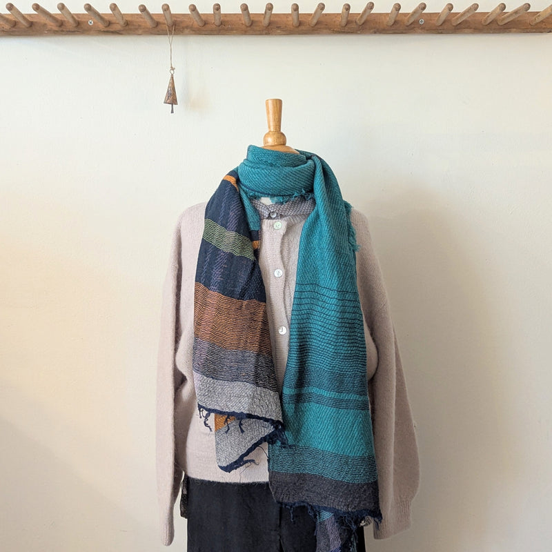 Scarf draped over a mannequin against a white wall