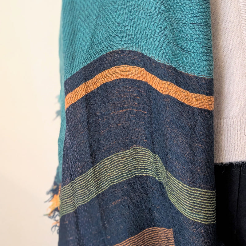 Textured fabric with blue, green, and orange patterns on a beige background