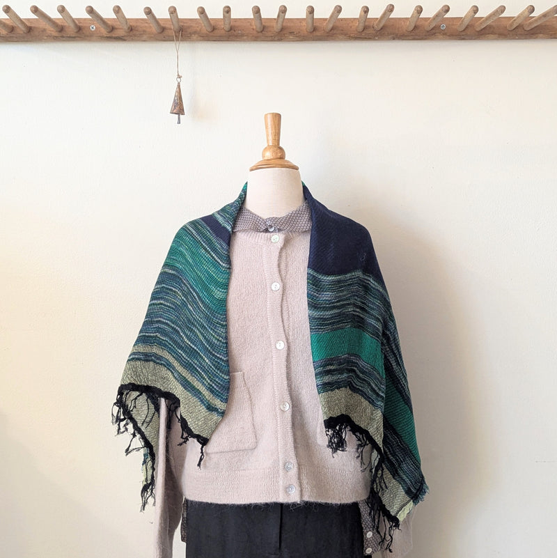 Mannequin wearing a striped scarf with a neutral background