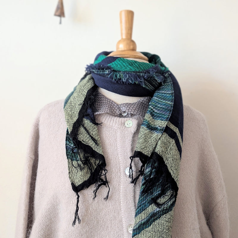 Mannequin wearing a patterned scarf with a neutral background