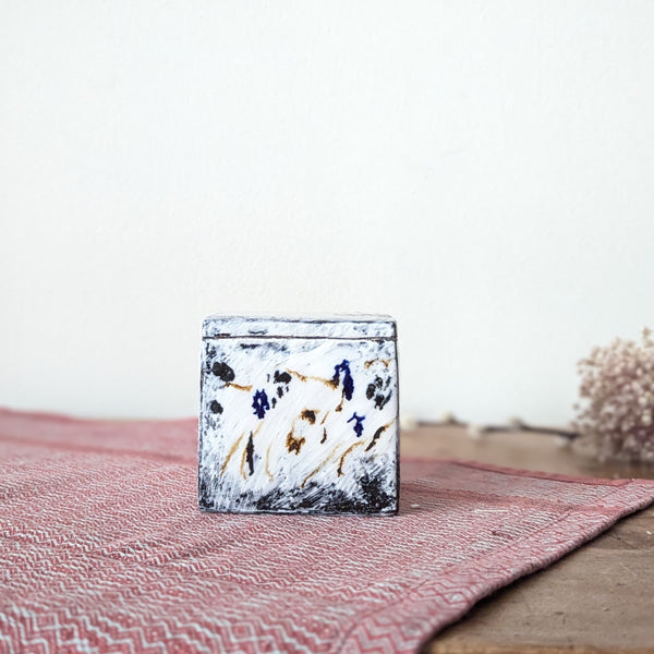 Decorative ceramic box with abstract design on a textured surface