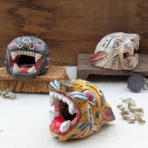 three wooden feline masks on netrual bacground