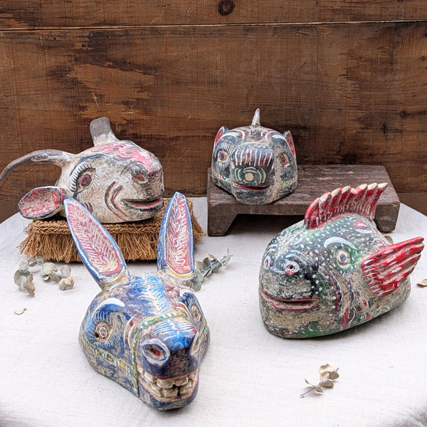 four wooden aminal masks on a neutral background