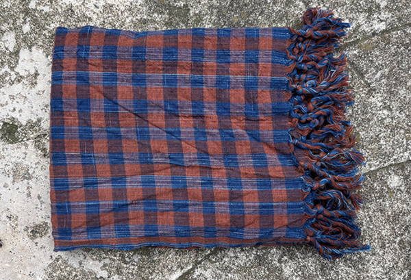 indigo and Brown Plaid towel with frayed edges on a textured surface