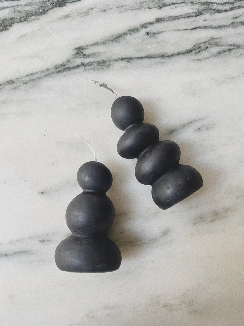 Black stacked sphere candle on a marble surface