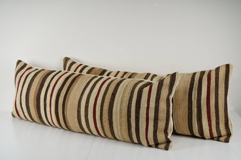 Two striped pillows on a white surface with a light gray background
