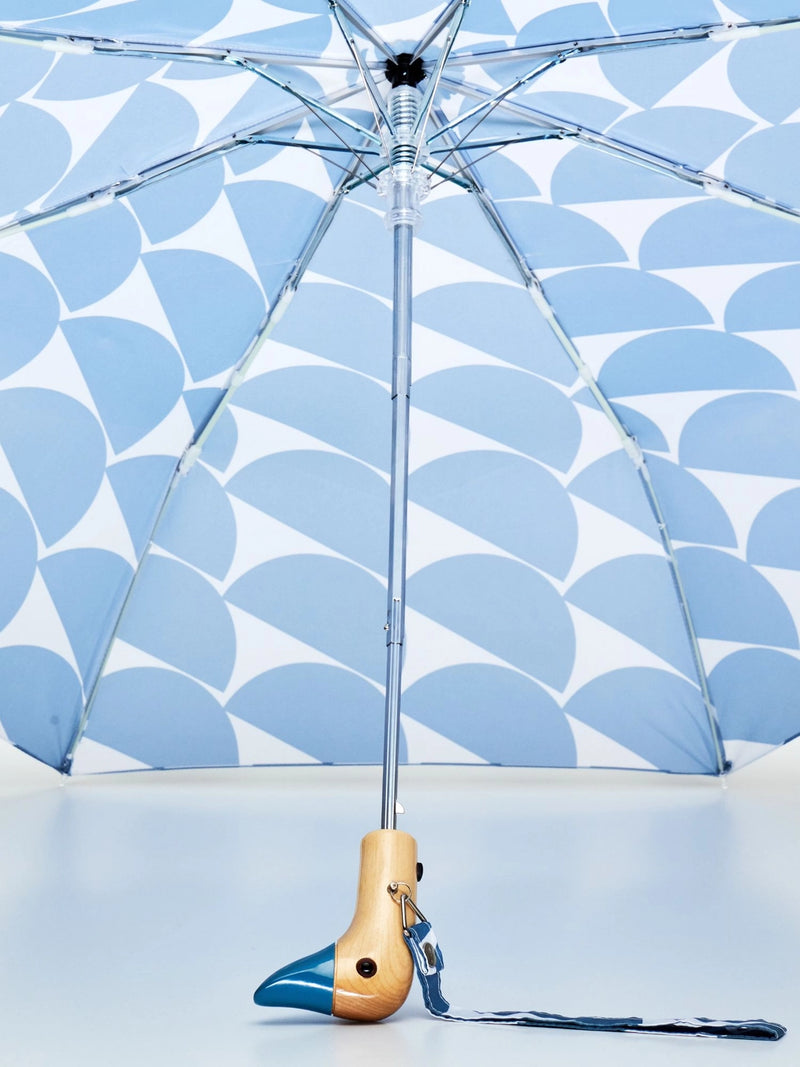 Umbrella with blue half circle pattern with duck head handle against a matching background