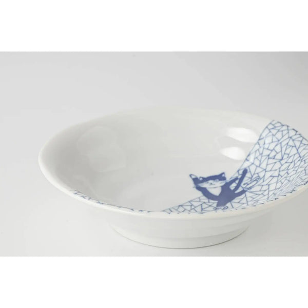White ceramic bowl with blue geometric design with a cat ice skating on a white background