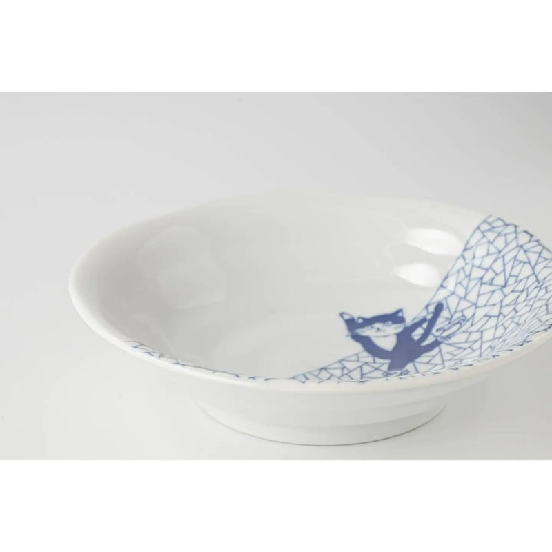 White ceramic bowl with blue geometric design with a cat ice skating on a white background