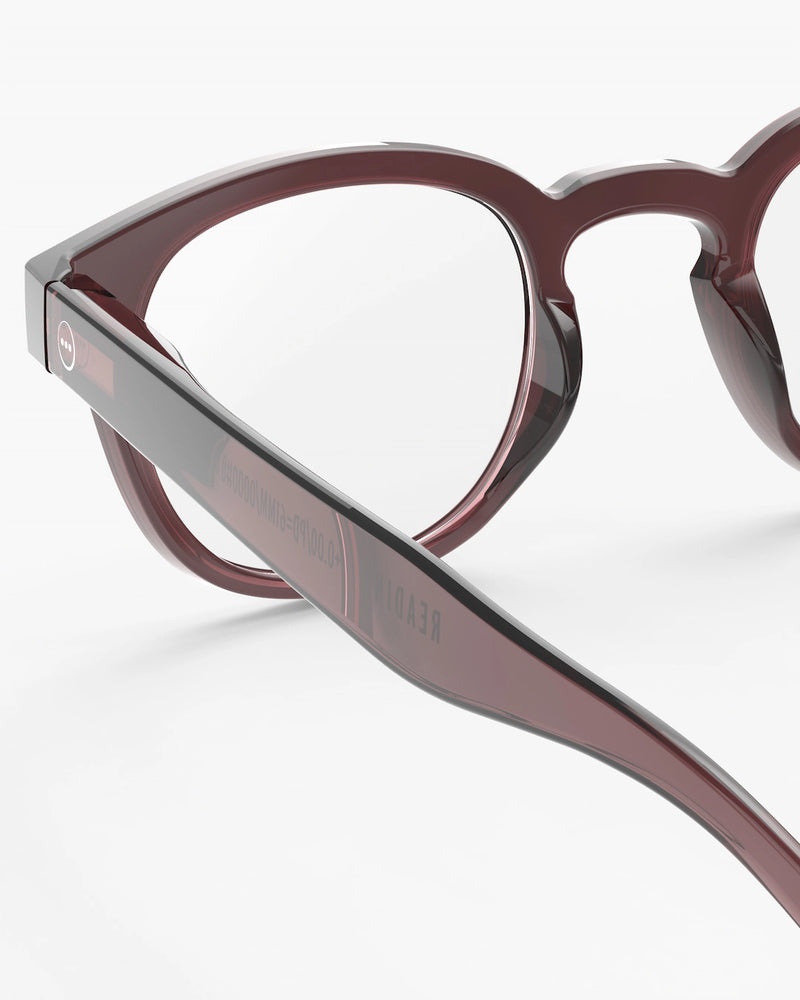 Close-up of a pair of eyeglasses with a brown frame on a white background