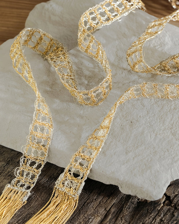 Gold lace ribbon on a textured stone surface