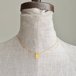 Tab talisman necklace by River Song jewelry. 24k gold over sterling silver. Nylon cord.