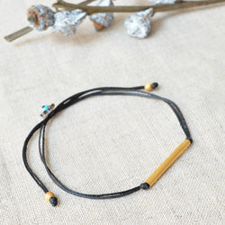 Gold bar bracelet with black cord. 7" adjustable cord. 