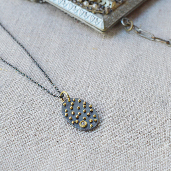 Nikki Nation oxidized silver and 18K gold acrux necklace. 