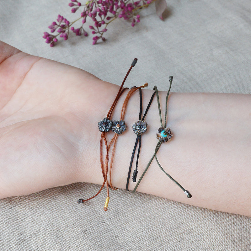 Gold bar bracelet with black cord. 7" adjustable cord. 