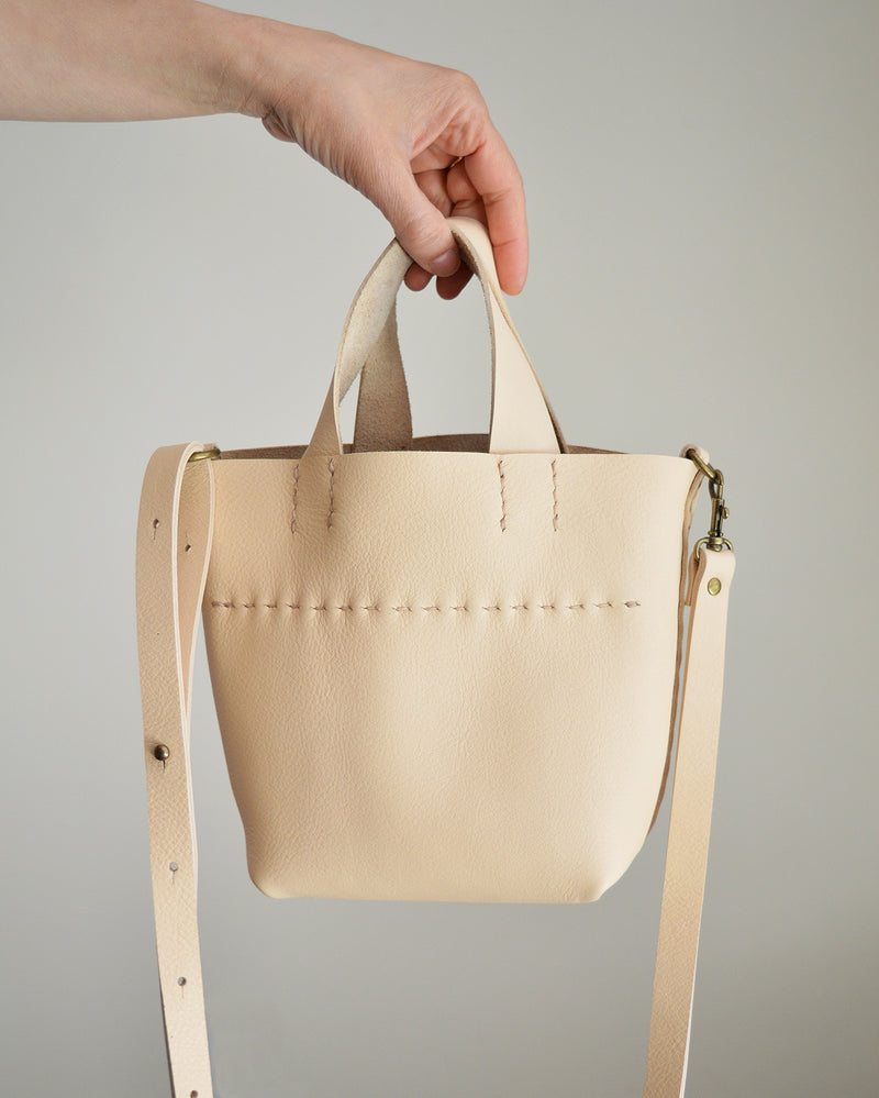 Stitch and Tickle mini bucket tote handmade of soft, medium weight, vegetable tanned leather. The leather will darken beautifully with age. Hand sewn. Made in Boston.
