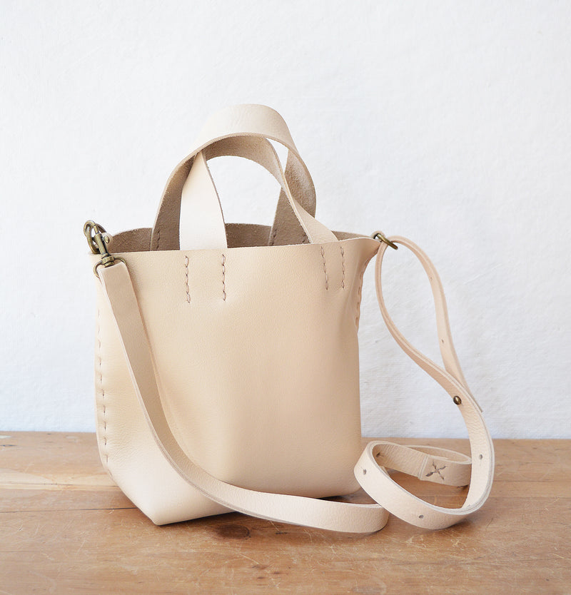 Stitch and Tickle mini bucket tote handmade of soft, medium weight, vegetable tanned leather. The leather will darken beautifully with age. Hand sewn. Made in Boston.